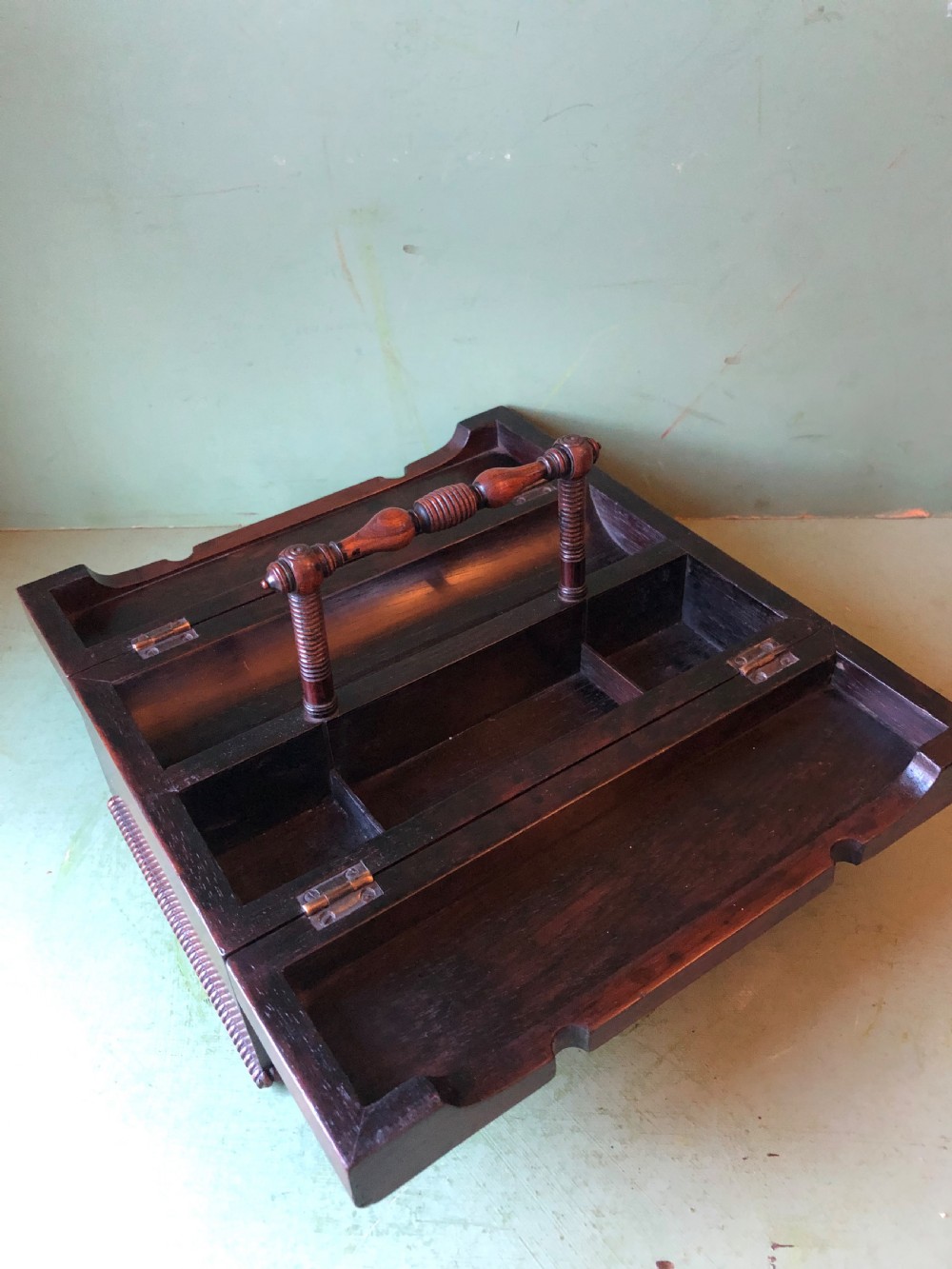 A dark rosewood rectangular desk tidy featuring a central turned wood and brass handle, hinged lids, and a moulded base. View XXIV