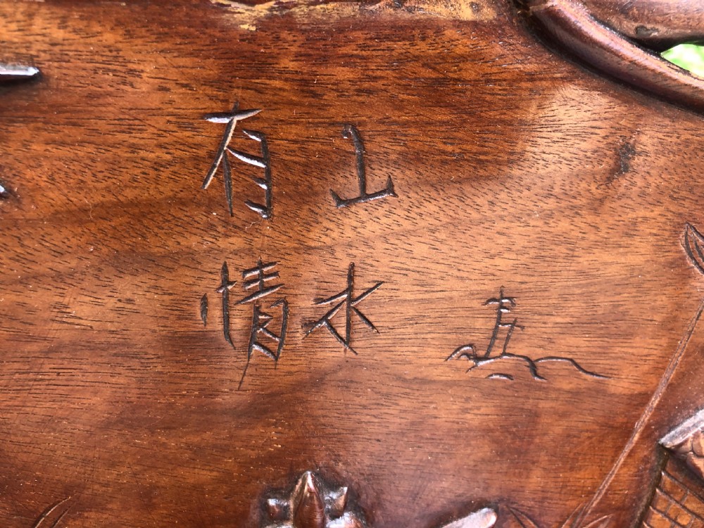 An antique Chinese dark hardwood hall bench featuring detailed relief carvings of bats, landscapes, and traditional character motifs on the backrest. View XI