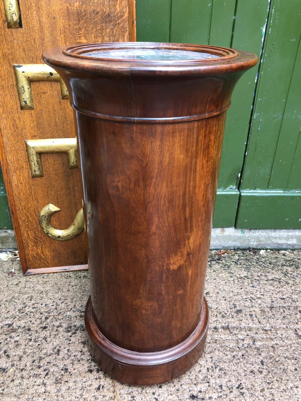 An early nineteenth-century French Empire mahogany cylindrical cupboard featuring an inset marble top, a single curved door with a small brass knob, and a plinth base. View VI