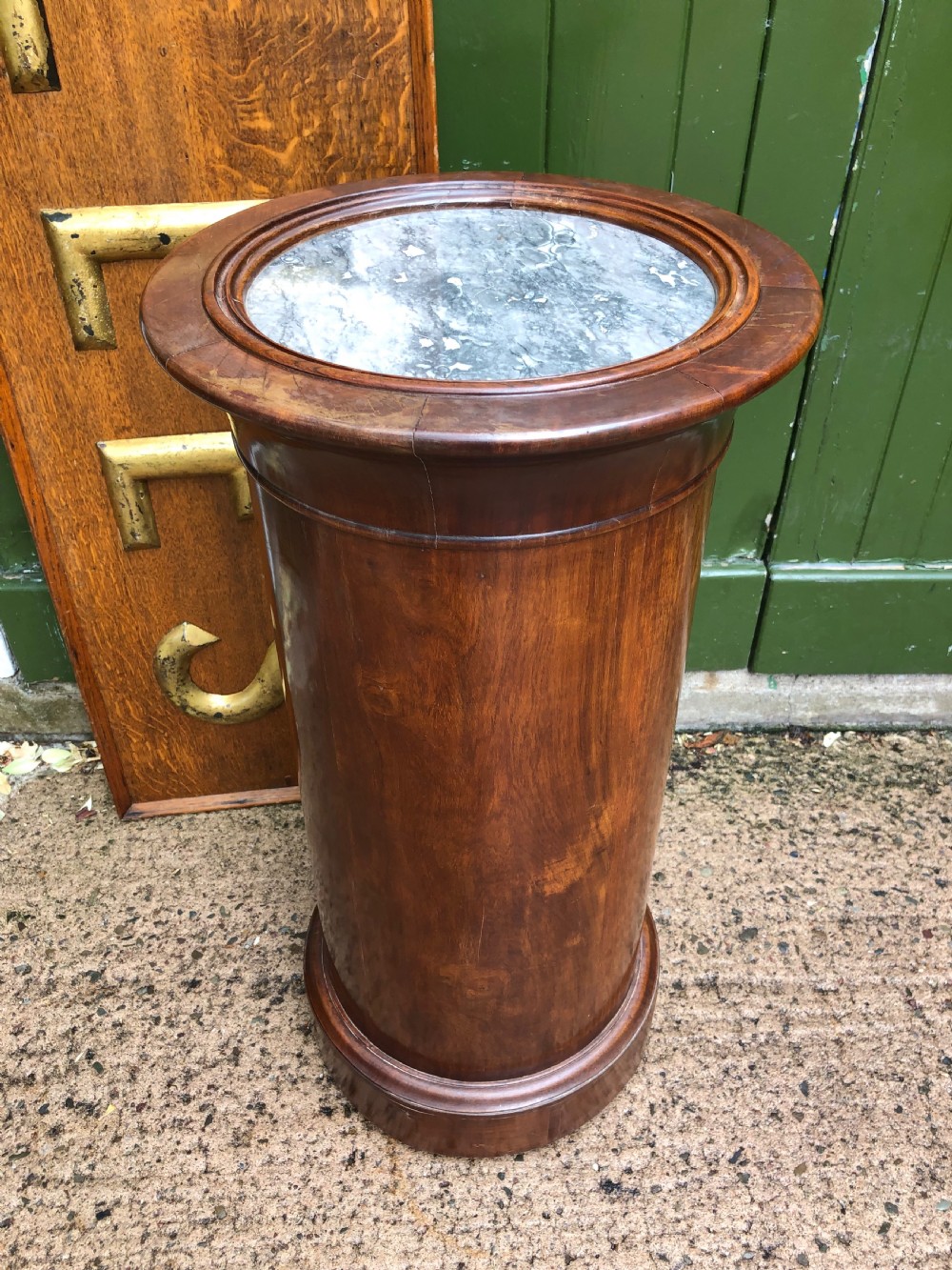 An early nineteenth-century French Empire mahogany cylindrical cupboard featuring an inset marble top, a single curved door with a small brass knob, and a plinth base. View VII