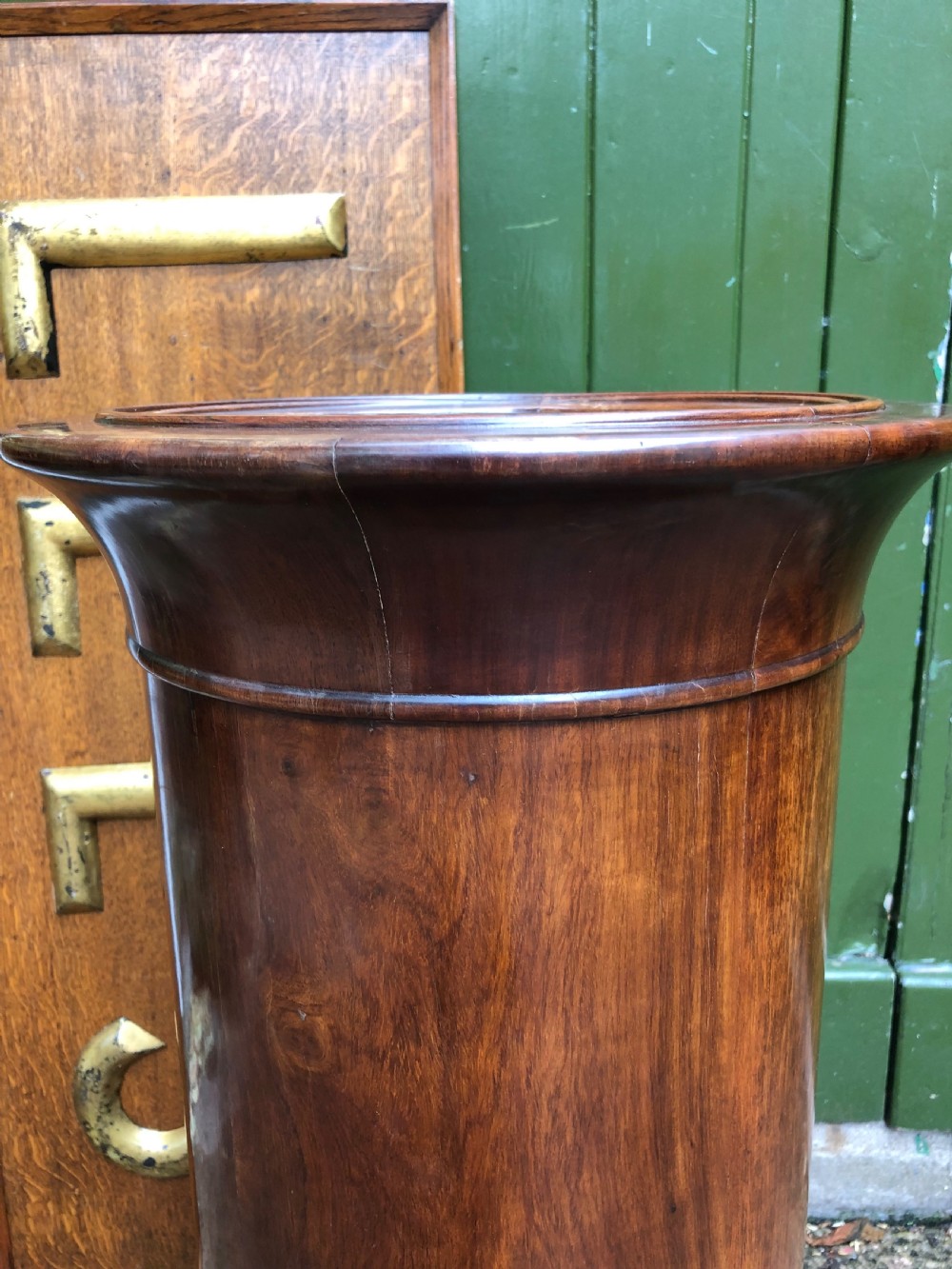 An early nineteenth-century French Empire mahogany cylindrical cupboard featuring an inset marble top, a single curved door with a small brass knob, and a plinth base. View VIII