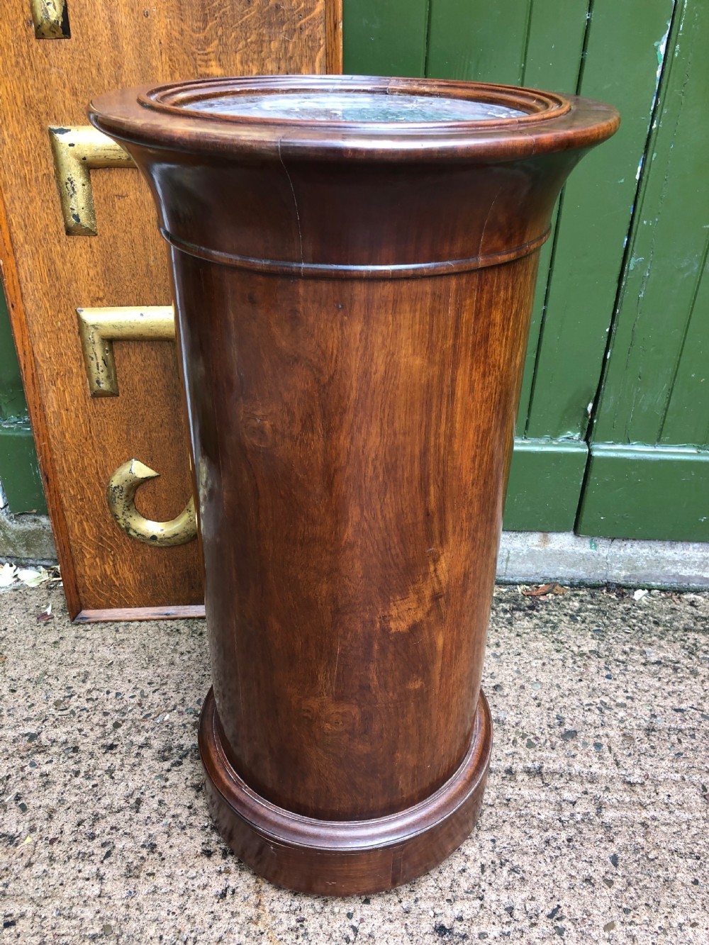 An early nineteenth-century French Empire mahogany cylindrical cupboard featuring an inset marble top, a single curved door with a small brass knob, and a plinth base. View IX