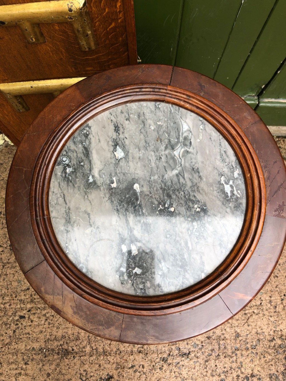 An early nineteenth-century French Empire mahogany cylindrical cupboard featuring an inset marble top, a single curved door with a small brass knob, and a plinth base. View XI