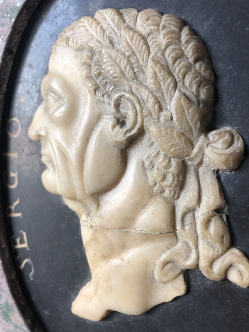 A pair of octagonal mottled pink marble plaques featuring carved off-white marble profile portraits of Roman emperors Vespasian and Galba set against black oval backgrounds. View X