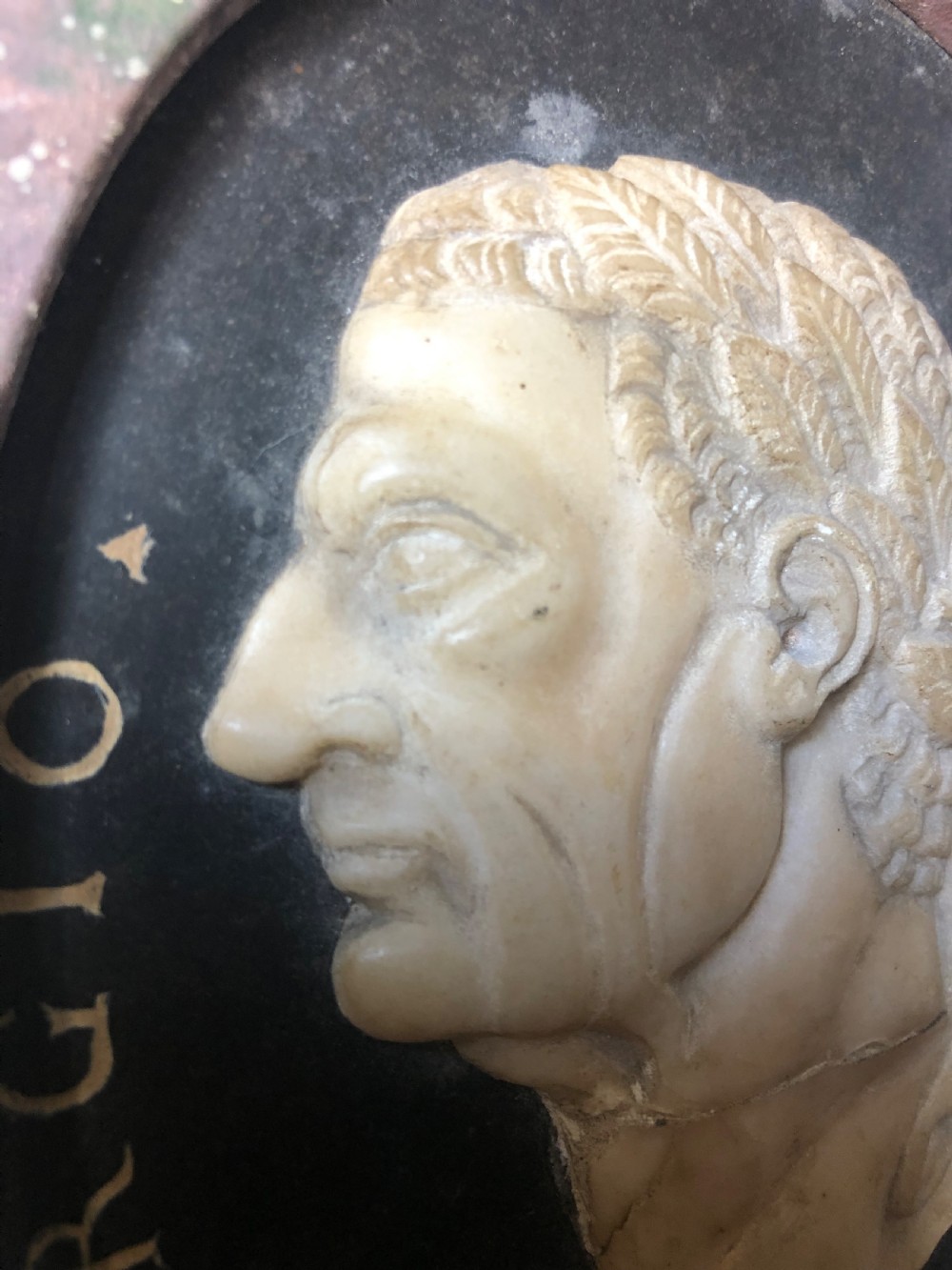 A pair of octagonal mottled pink marble plaques featuring carved off-white marble profile portraits of Roman emperors Vespasian and Galba set against black oval backgrounds. View XI