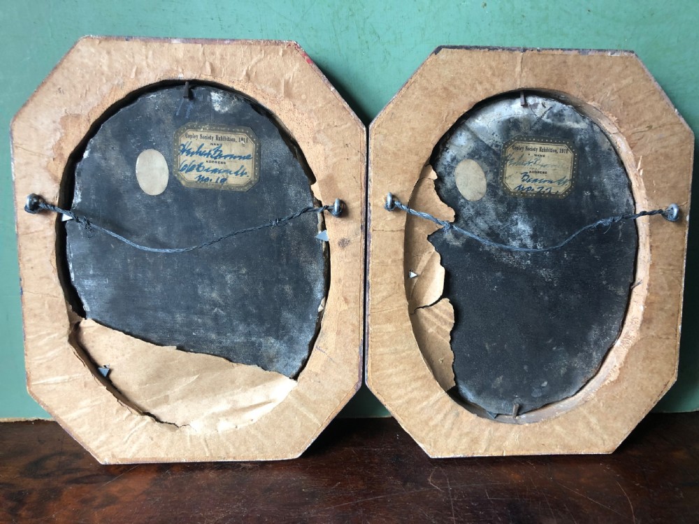 A pair of octagonal mottled pink marble plaques featuring carved off-white marble profile portraits of Roman emperors Vespasian and Galba set against black oval backgrounds. View XIV
