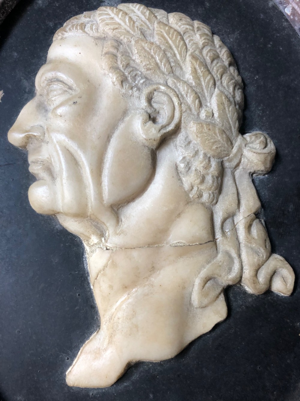 A pair of octagonal mottled pink marble plaques featuring carved off-white marble profile portraits of Roman emperors Vespasian and Galba set against black oval backgrounds. View XX