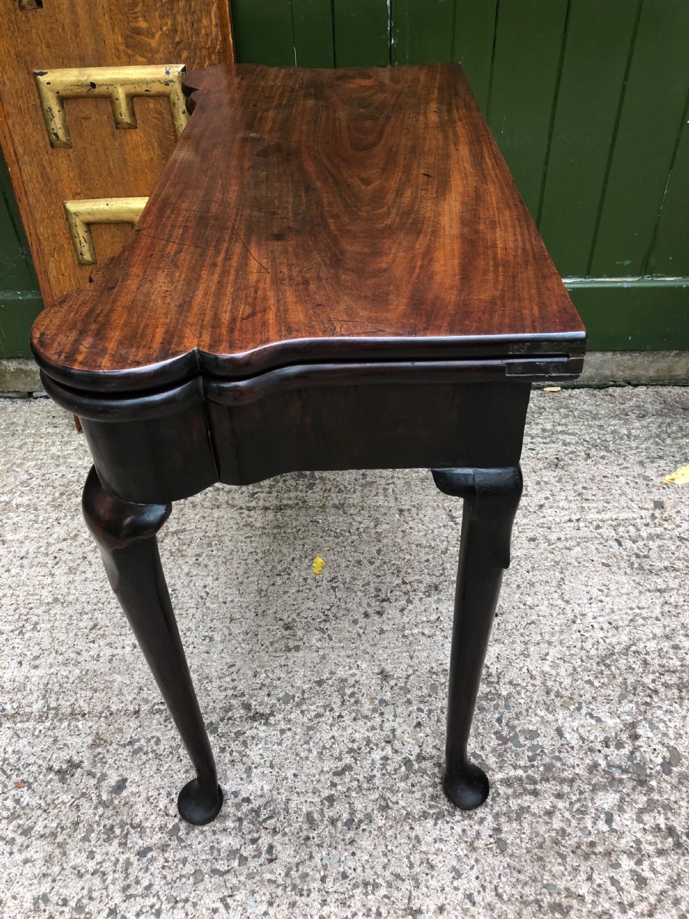 A mid-18th-century George II mahogany fold-over card table featuring slender cabriole legs terminating in pad feet and a shaped top. View VIII