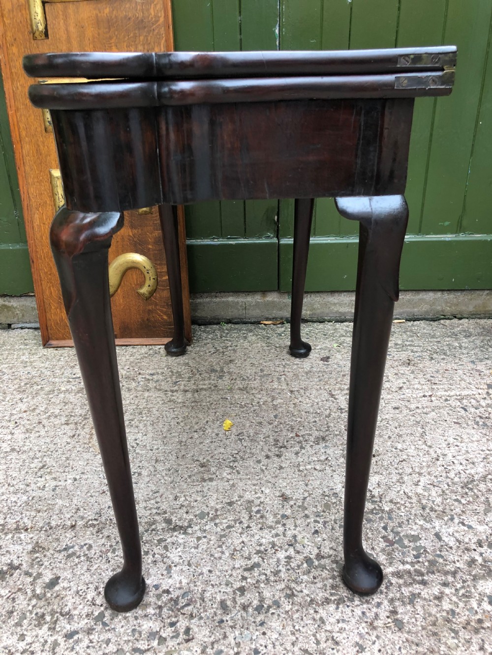 A mid-18th-century George II mahogany fold-over card table featuring slender cabriole legs terminating in pad feet and a shaped top. View XIV