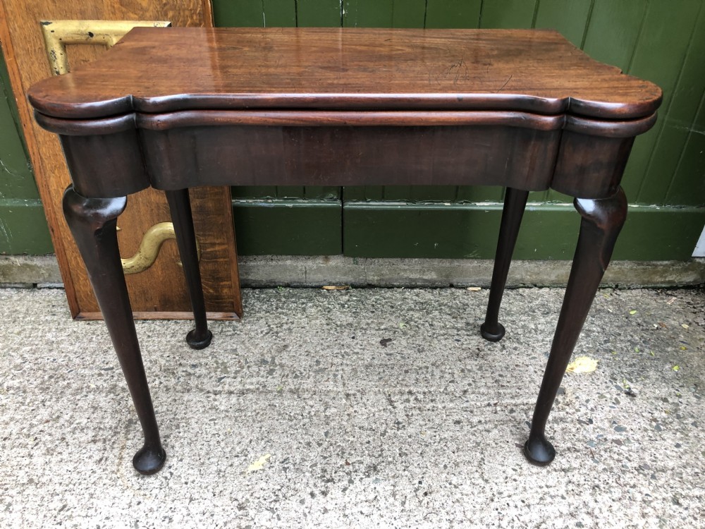 A mid-18th-century George II mahogany fold-over card table featuring slender cabriole legs terminating in pad feet and a shaped top. View XXI