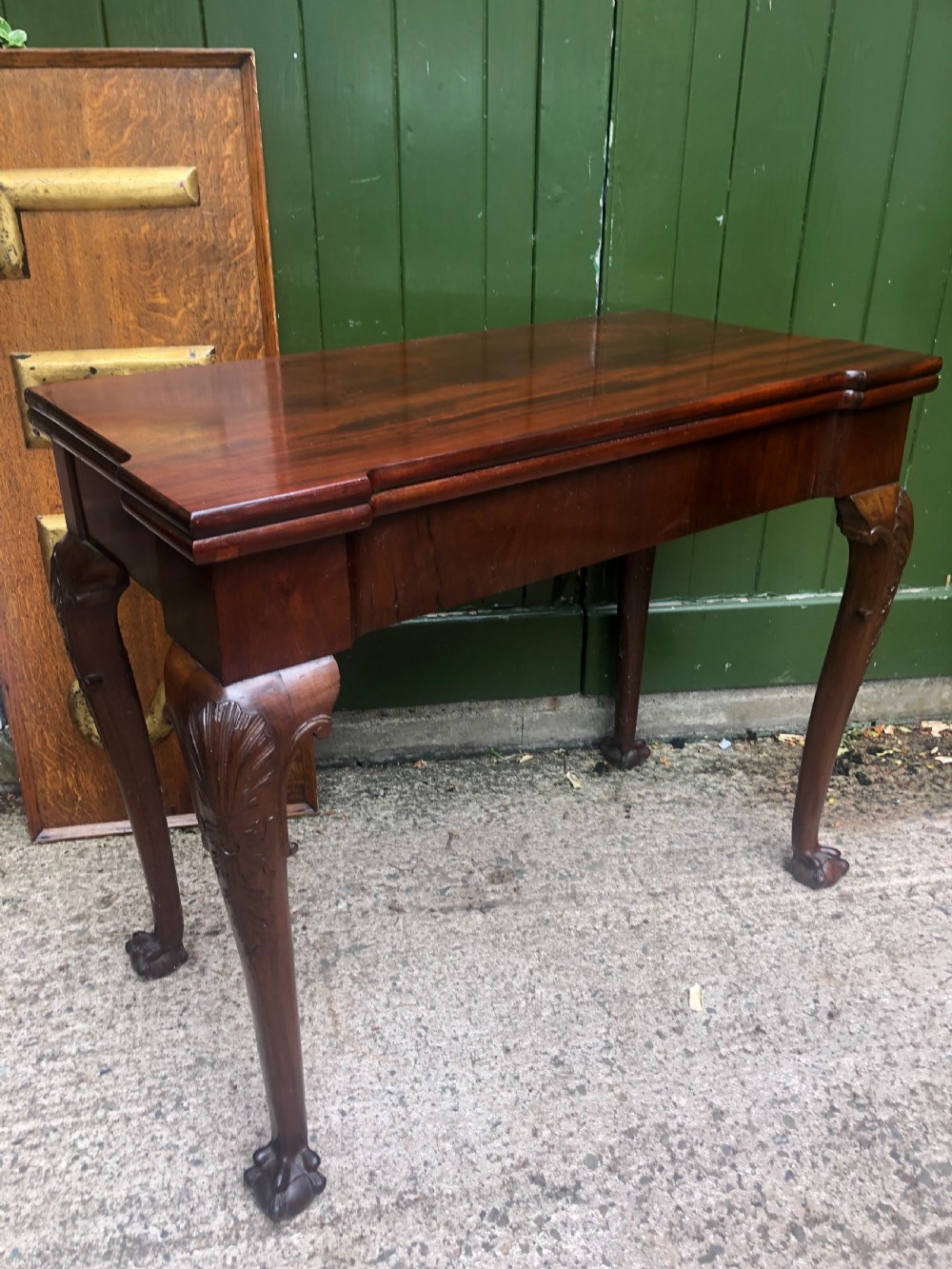 A mid-18th-century George II mahogany fold-over card table featuring carved cabriole legs and claw and ball feet. View VIII
