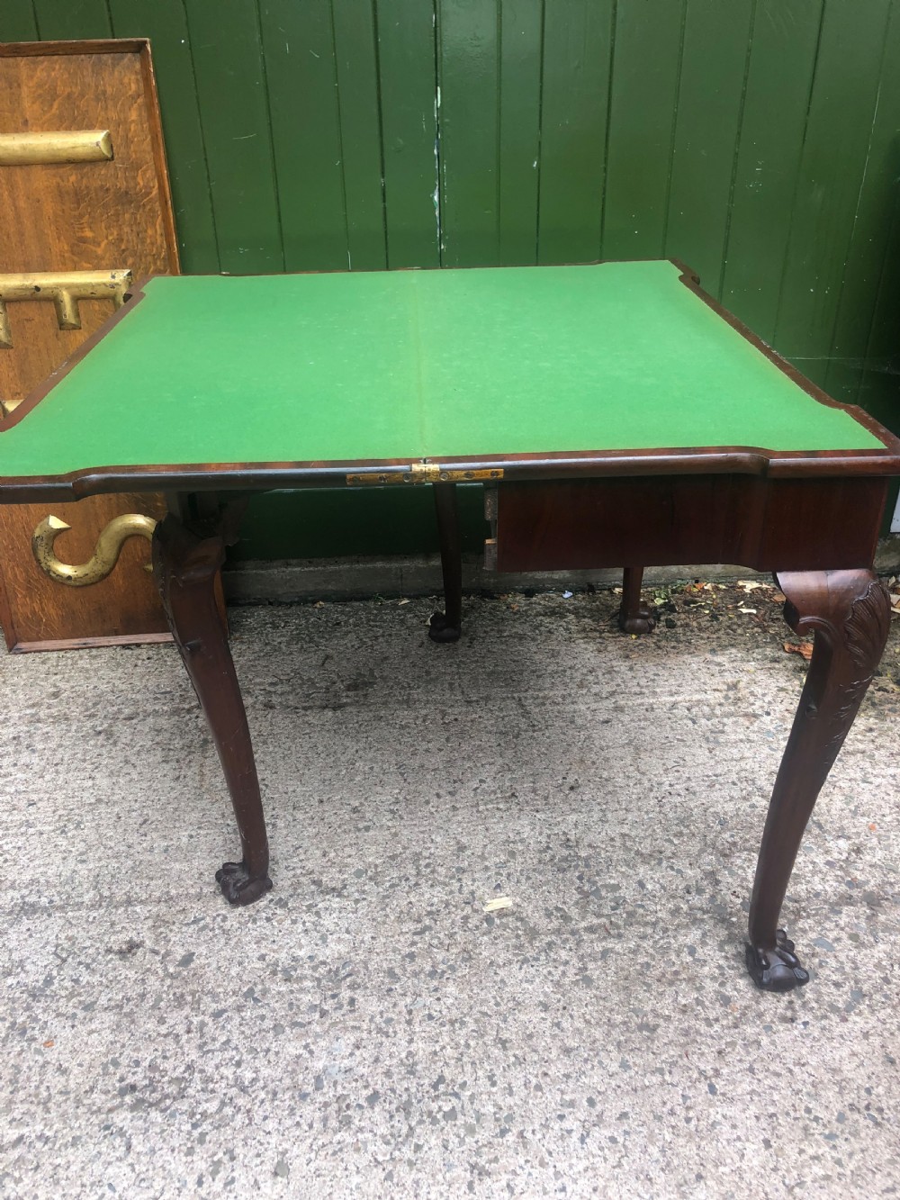 A mid-18th-century George II mahogany fold-over card table featuring carved cabriole legs and claw and ball feet. View X