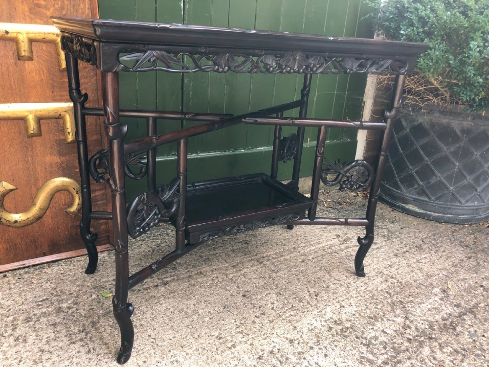 A late Qing dynasty dark carved hardwood tray table featuring faux-bamboo legs, carved foliage aprons, and a lower tier shelf. View III
