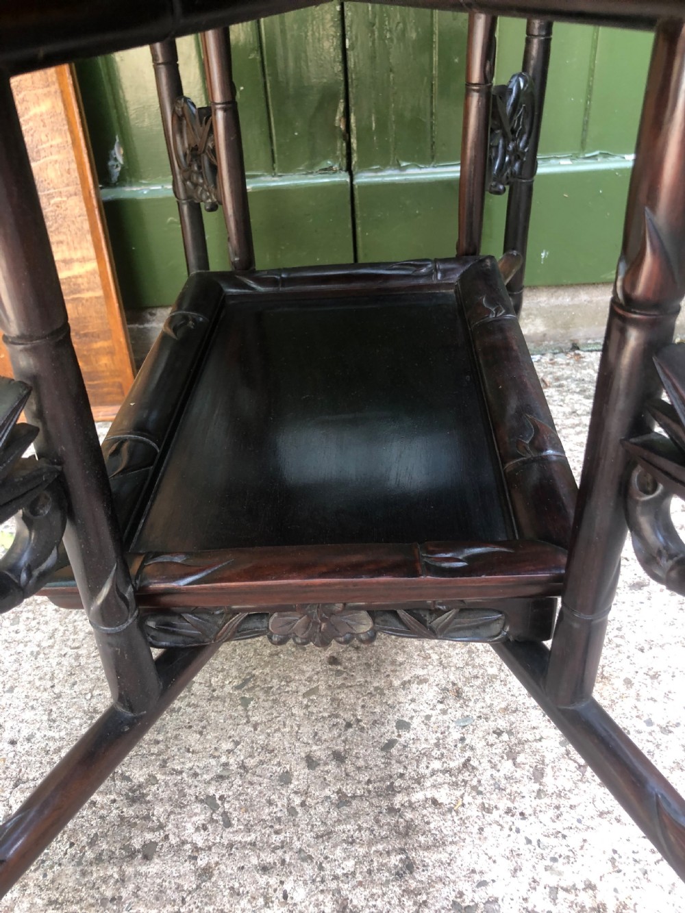 A late Qing dynasty dark carved hardwood tray table featuring faux-bamboo legs, carved foliage aprons, and a lower tier shelf. View VI