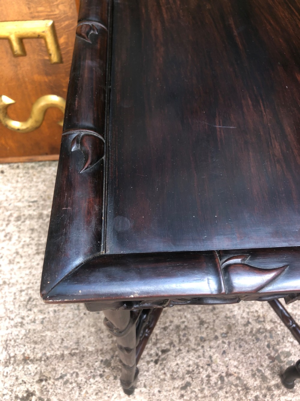 A late Qing dynasty dark carved hardwood tray table featuring faux-bamboo legs, carved foliage aprons, and a lower tier shelf. View VIII