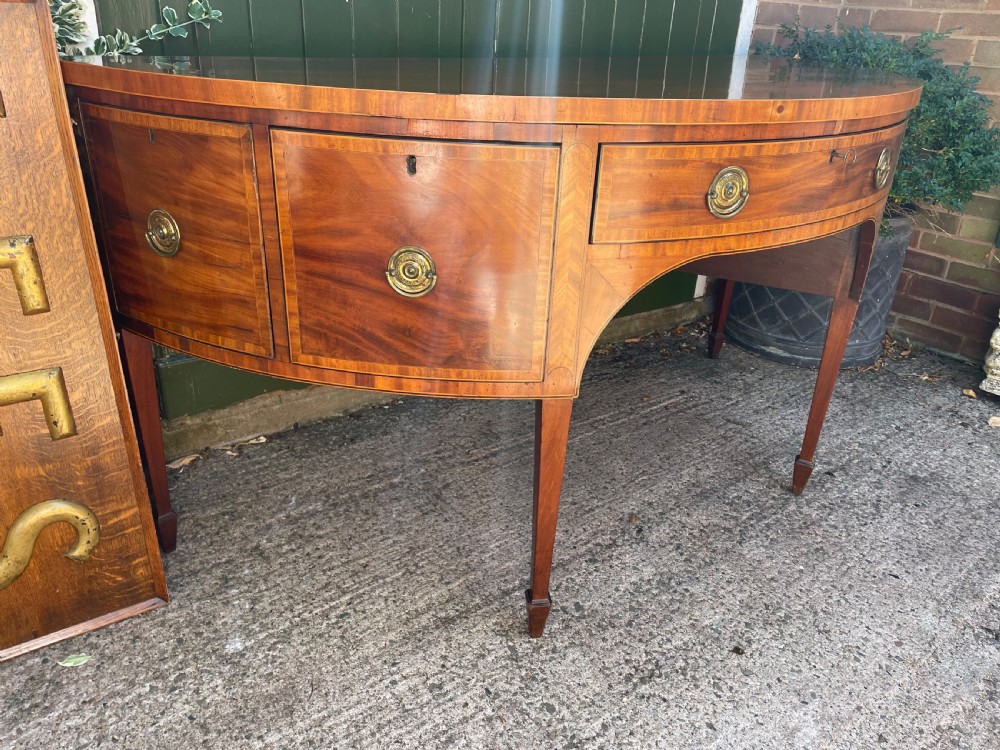 A late 18th-century George III mahogany demi-lune sideboard featuring inlaid stringing, a central drawer, curved side doors, and tapered square legs. View VII