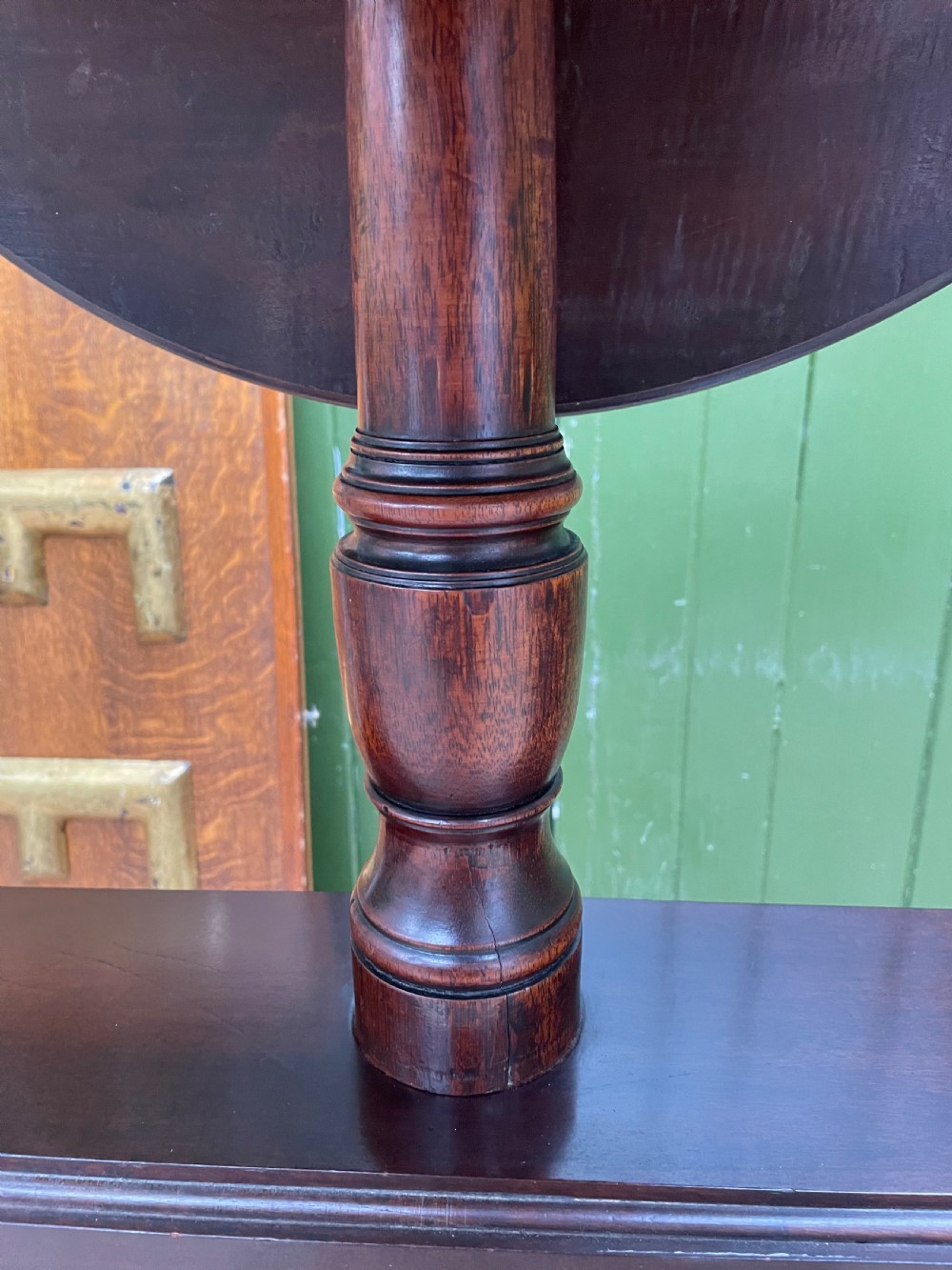 A late eighteenth-century George III mahogany two-tiered dumb waiter featuring drop-leaf circular shelves and a turned column on a tripod base with brass castors. View VII