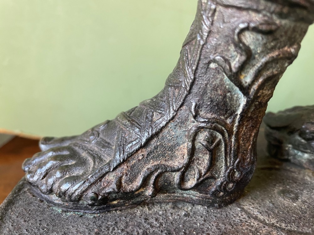 A dark patinated bronze figure depicting the nude classical youth Dionysus standing in contrapposto pose on a circular moulded base. View VIII