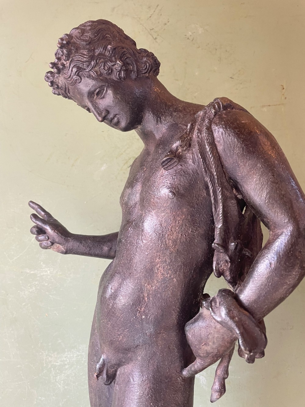 A dark patinated bronze figure depicting the nude classical youth Dionysus standing in contrapposto pose on a circular moulded base. View XI