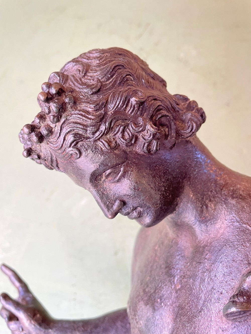 A dark patinated bronze figure depicting the nude classical youth Dionysus standing in contrapposto pose on a circular moulded base. View XIV