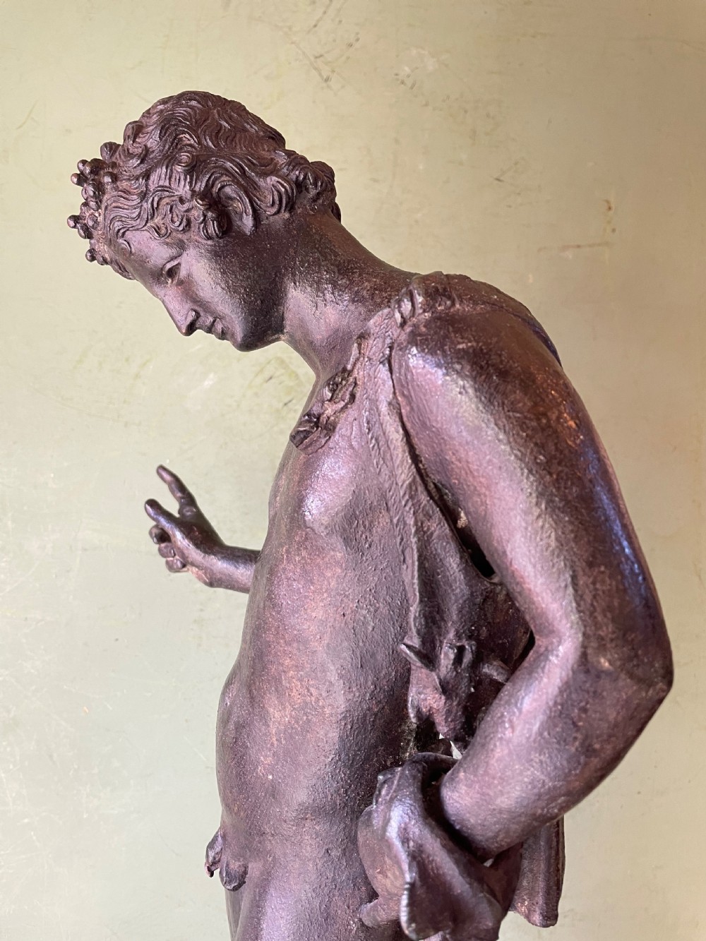 A dark patinated bronze figure depicting the nude classical youth Dionysus standing in contrapposto pose on a circular moulded base. View XVII