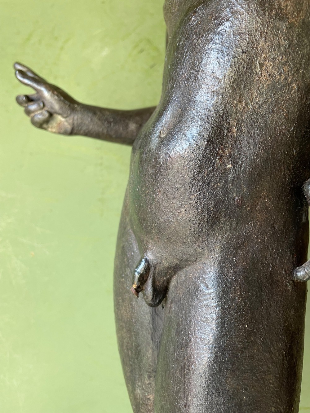 A dark patinated bronze figure depicting the nude classical youth Dionysus standing in contrapposto pose on a circular moulded base. View XIX