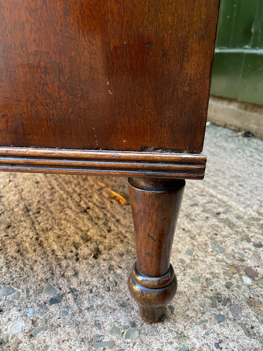 A George III Sheraton period mahogany chest of drawers featuring a curved serpentine front, four graduated drawers, brass swan-neck handles, and reeded corner columns. View XVIII
