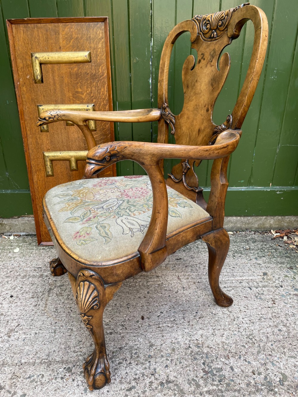 A carved walnut open armchair featuring carved eagle head arm terminals, a vasiform splat back, and floral tapestry upholstery. View V