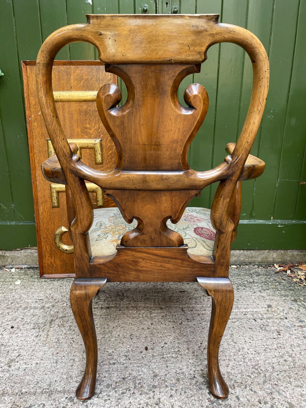A carved walnut open armchair featuring carved eagle head arm terminals, a vasiform splat back, and floral tapestry upholstery. View VI
