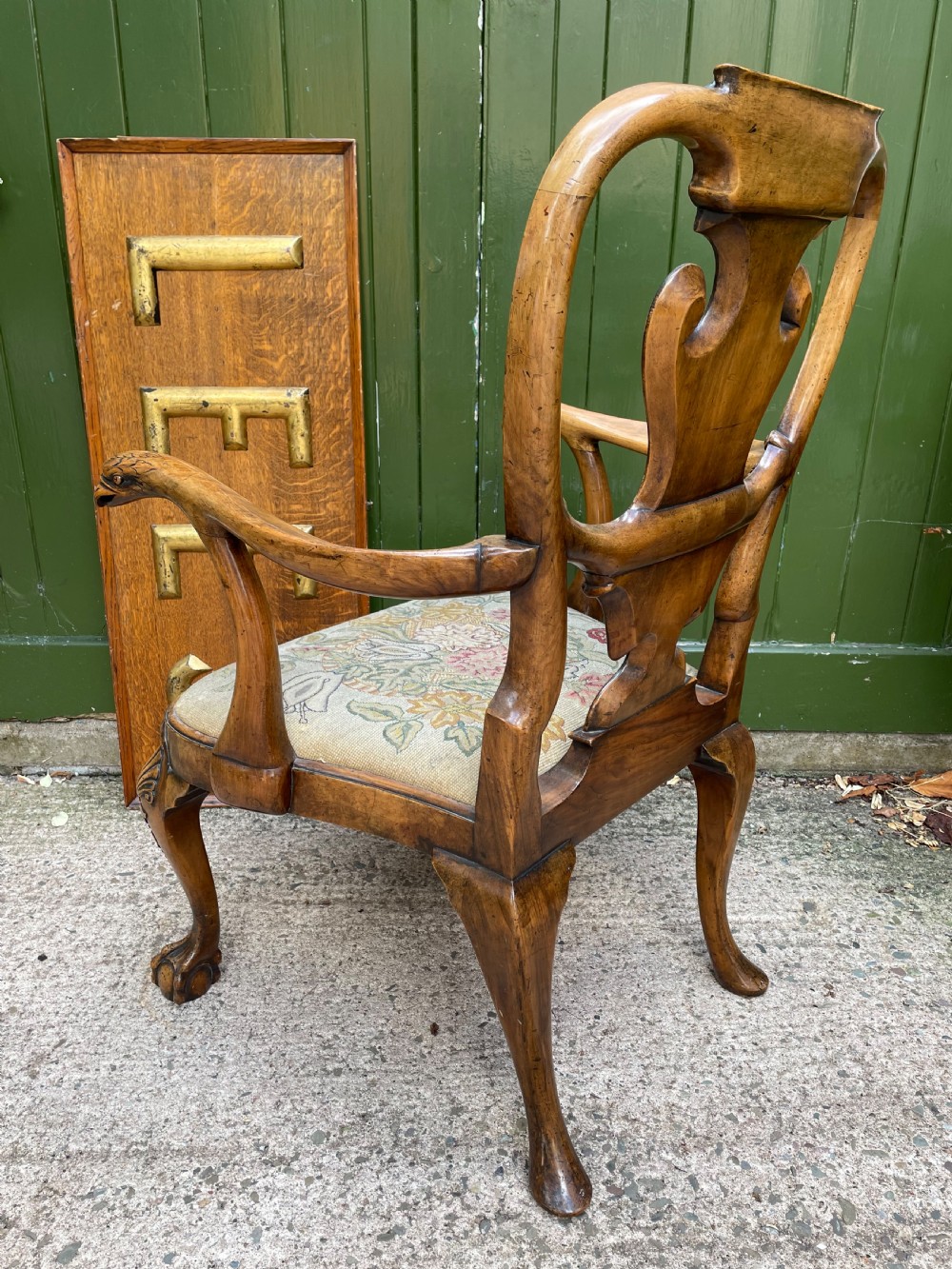 A carved walnut open armchair featuring carved eagle head arm terminals, a vasiform splat back, and floral tapestry upholstery. View VII