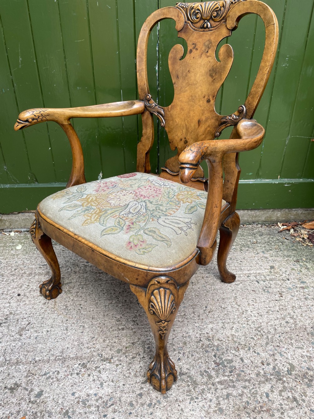 A carved walnut open armchair featuring carved eagle head arm terminals, a vasiform splat back, and floral tapestry upholstery. View X