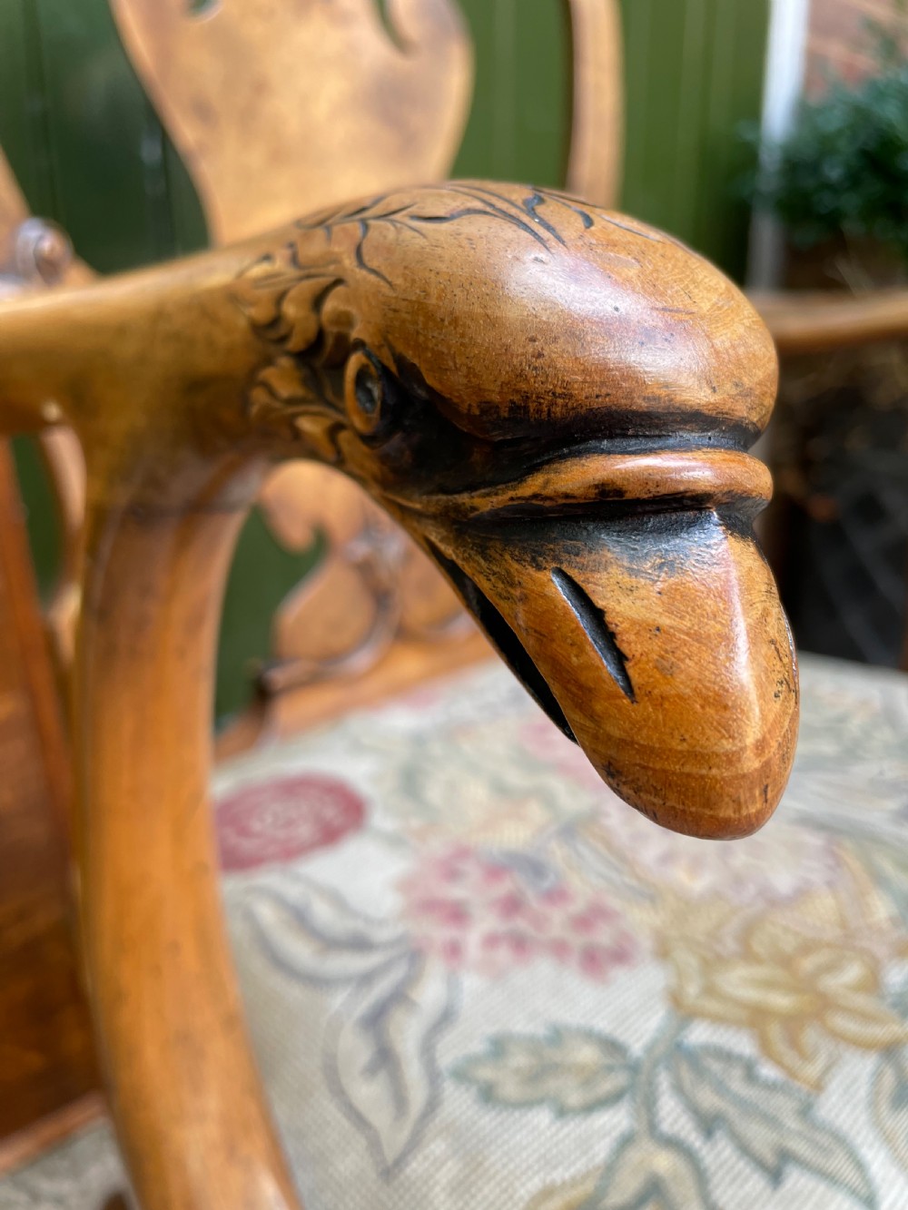 A carved walnut open armchair featuring carved eagle head arm terminals, a vasiform splat back, and floral tapestry upholstery. View XIV
