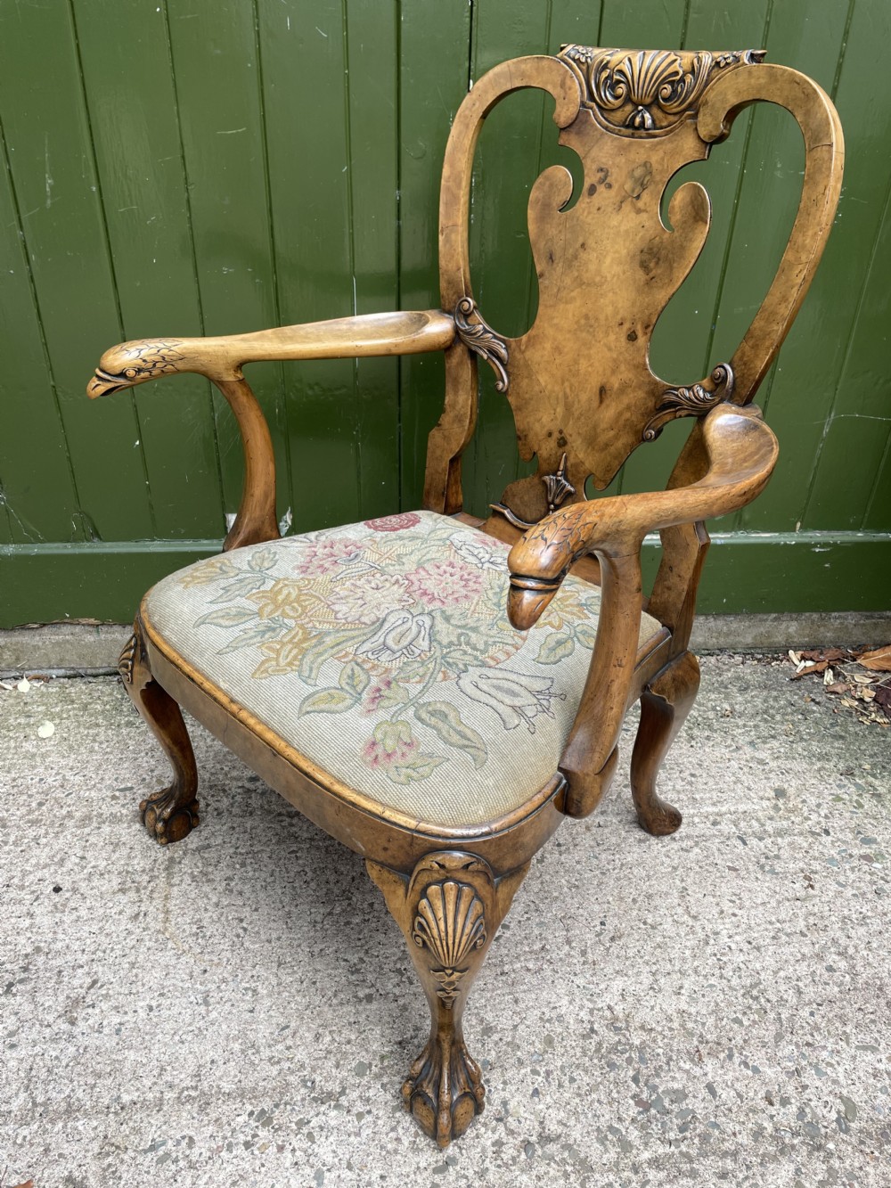 A carved walnut open armchair featuring carved eagle head arm terminals, a vasiform splat back, and floral tapestry upholstery. View XXV