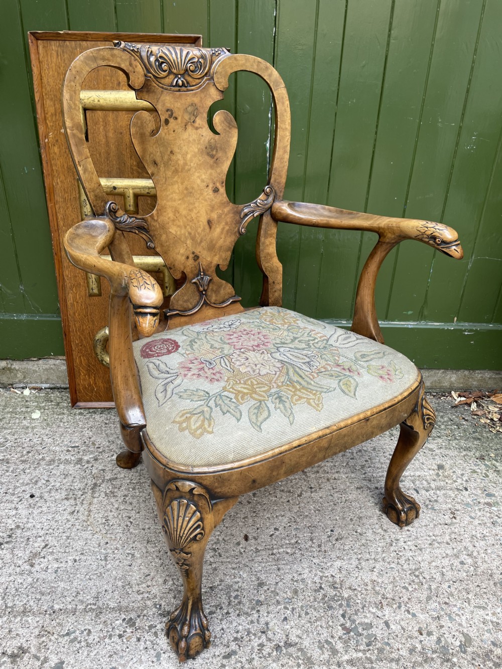 A carved walnut open armchair featuring carved eagle head arm terminals, a vasiform splat back, and floral tapestry upholstery. View XXVI