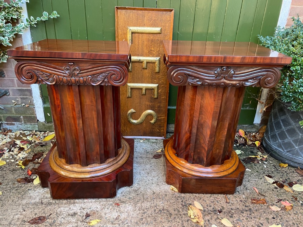 A matched pair of William IV mahogany pedestals designed in classical ionic column form with fluted shafts and stepped bases.