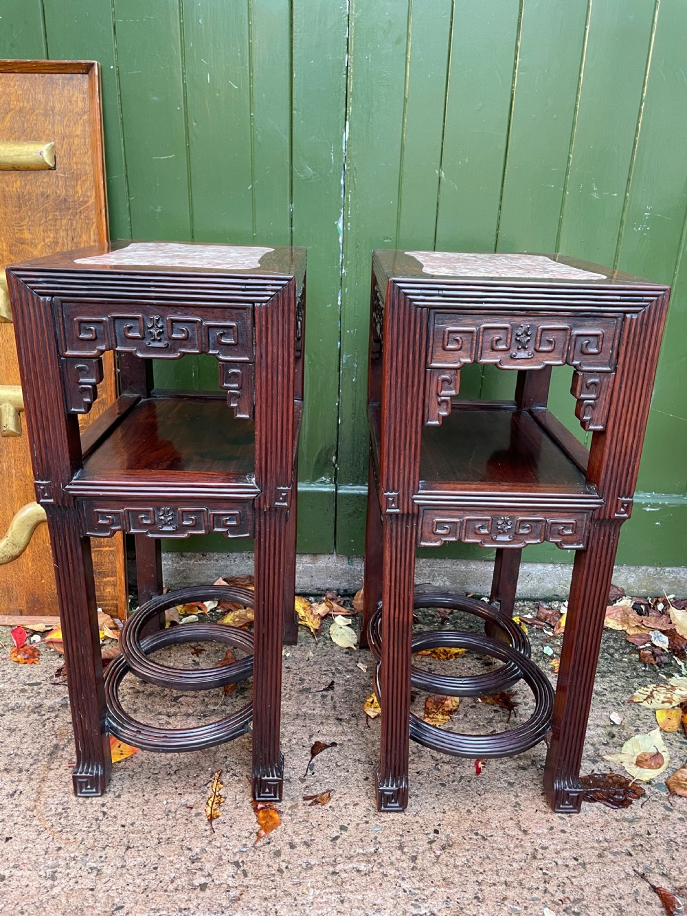 A pair of late nineteenth-century Chinese carved dark hardwood two-tier stands featuring inset marble tops, carved openwork aprons, and interlocking ring stretchers. View III