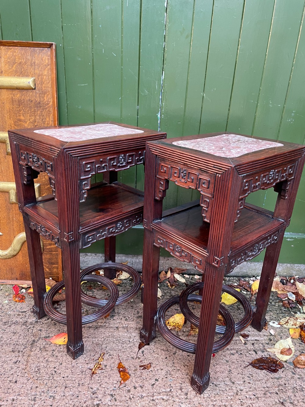 A pair of late nineteenth-century Chinese carved dark hardwood two-tier stands featuring inset marble tops, carved openwork aprons, and interlocking ring stretchers. View VIII