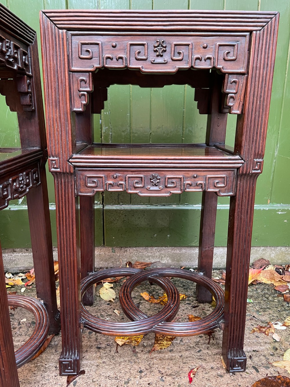 A pair of late nineteenth-century Chinese carved dark hardwood two-tier stands featuring inset marble tops, carved openwork aprons, and interlocking ring stretchers. View XIV