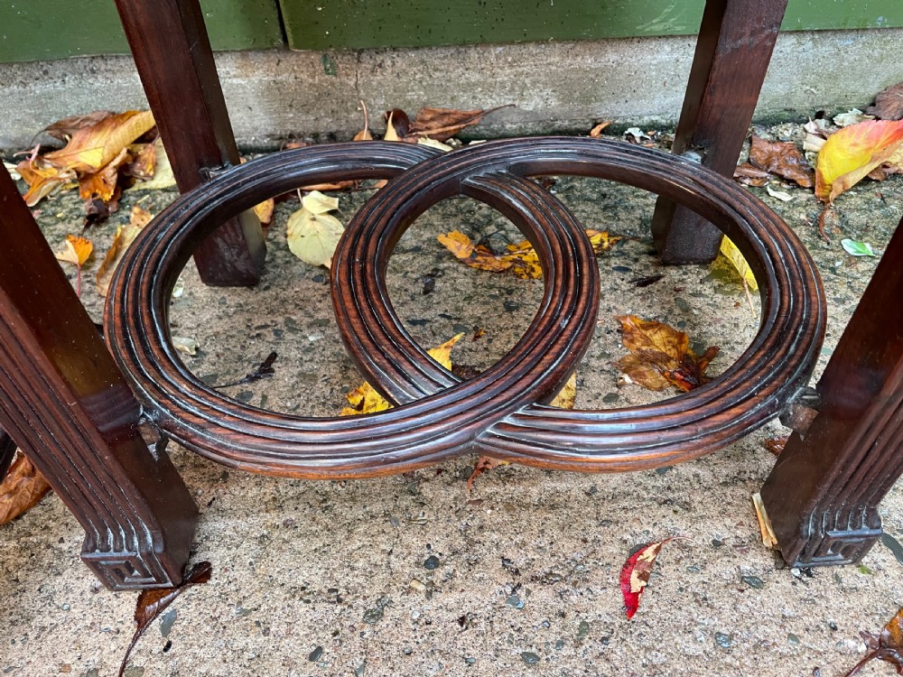 A pair of late nineteenth-century Chinese carved dark hardwood two-tier stands featuring inset marble tops, carved openwork aprons, and interlocking ring stretchers. View XV