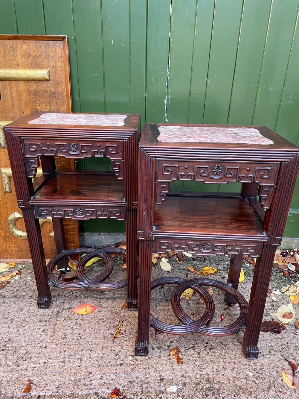 A pair of late nineteenth-century Chinese carved dark hardwood two-tier stands featuring inset marble tops, carved openwork aprons, and interlocking ring stretchers. View XVI