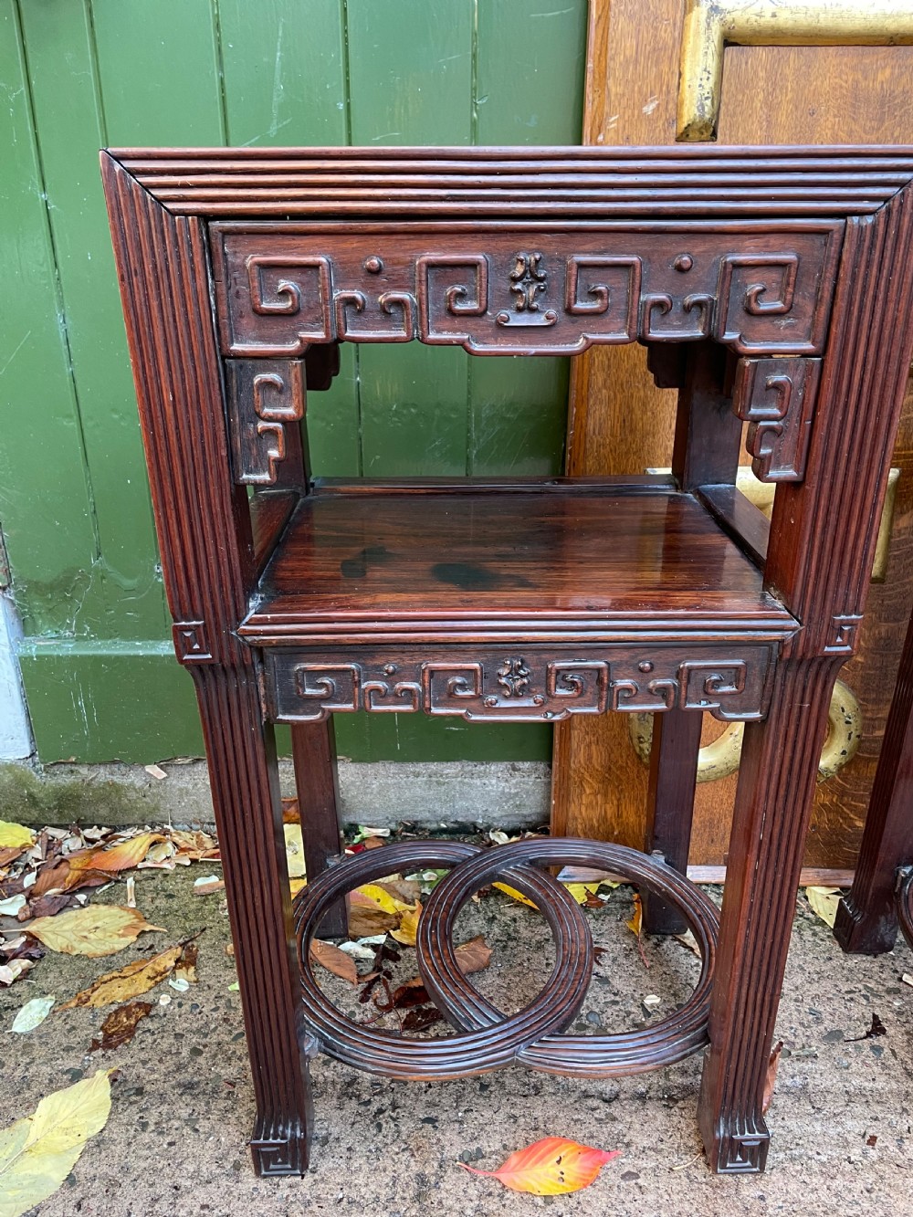A pair of late nineteenth-century Chinese carved dark hardwood two-tier stands featuring inset marble tops, carved openwork aprons, and interlocking ring stretchers. View XIX