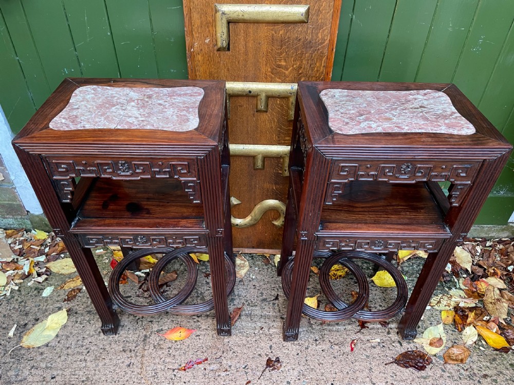 A pair of late nineteenth-century Chinese carved dark hardwood two-tier stands featuring inset marble tops, carved openwork aprons, and interlocking ring stretchers. View XXI