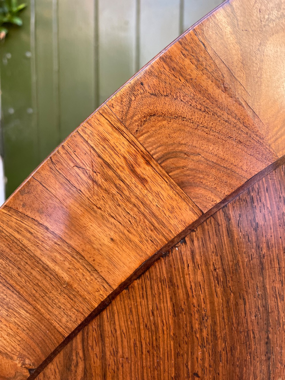 An early nineteenth-century circular Regency rosewood centre table featuring a crossbanded border, displayed in a tilted position on a pedestal base with castors. View II