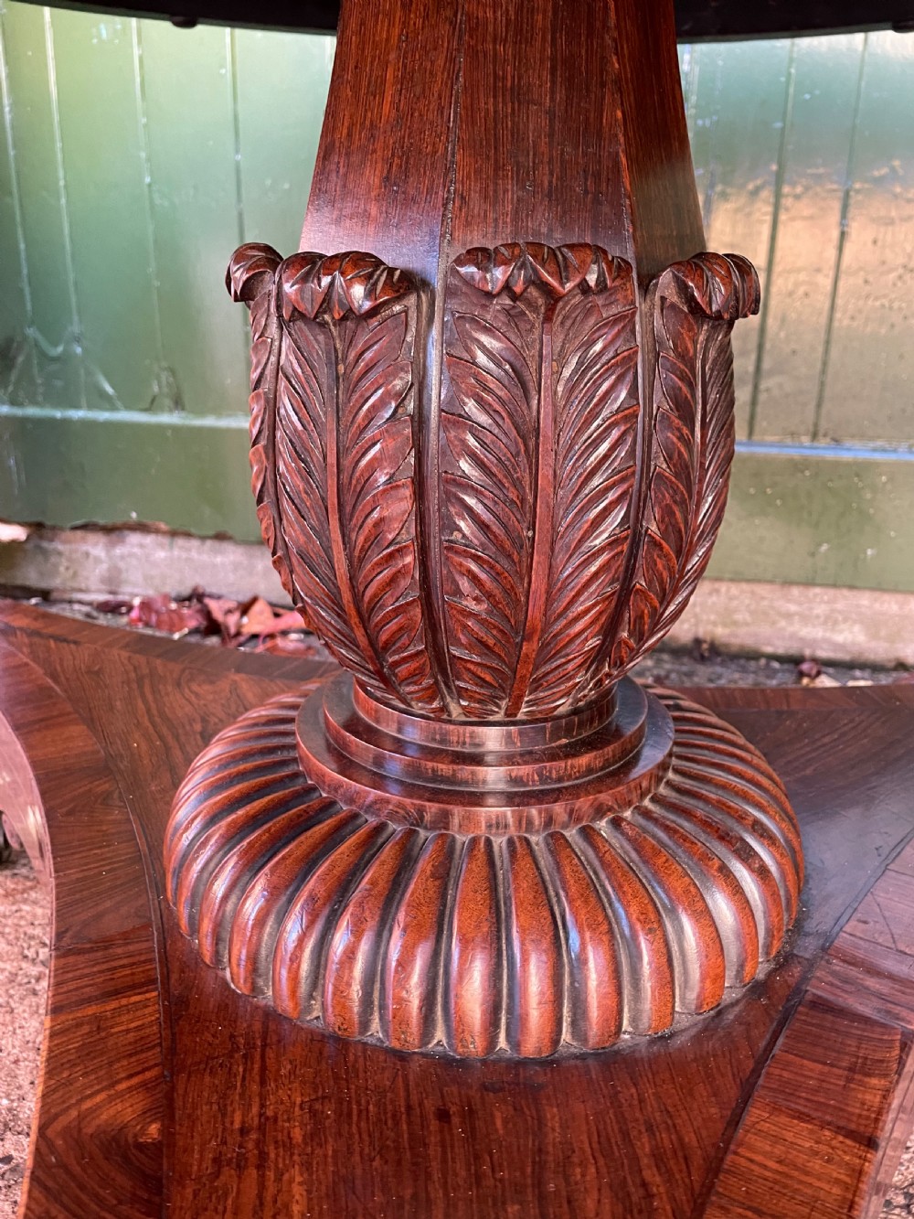An early nineteenth-century circular Regency rosewood centre table featuring a crossbanded border, displayed in a tilted position on a pedestal base with castors. View XIV