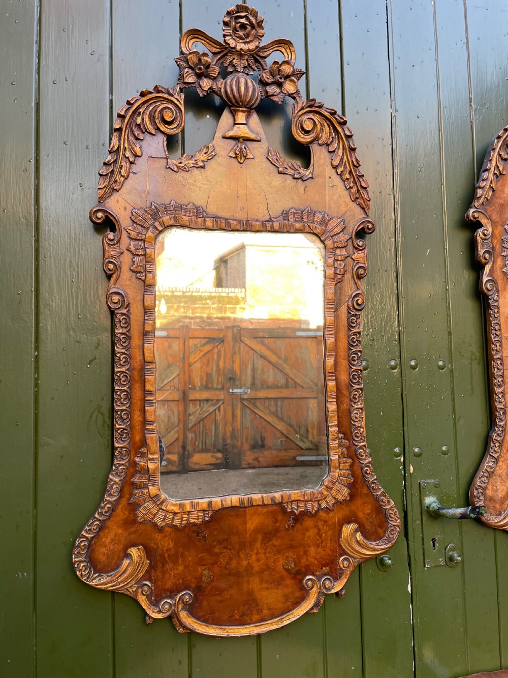 A pair of late nineteenth century carved walnut and parcel-gilt wall consoles with matching arch-top mirrors featuring urn and floral cresting. View V