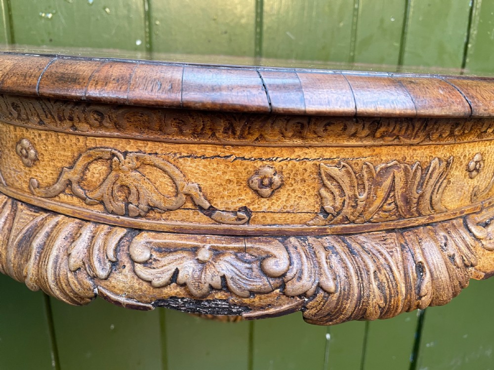 A pair of late nineteenth century carved walnut and parcel-gilt wall consoles with matching arch-top mirrors featuring urn and floral cresting. View VII