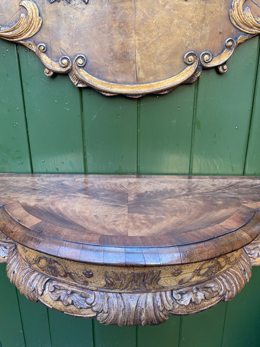 A pair of late nineteenth century carved walnut and parcel-gilt wall consoles with matching arch-top mirrors featuring urn and floral cresting. View XV
