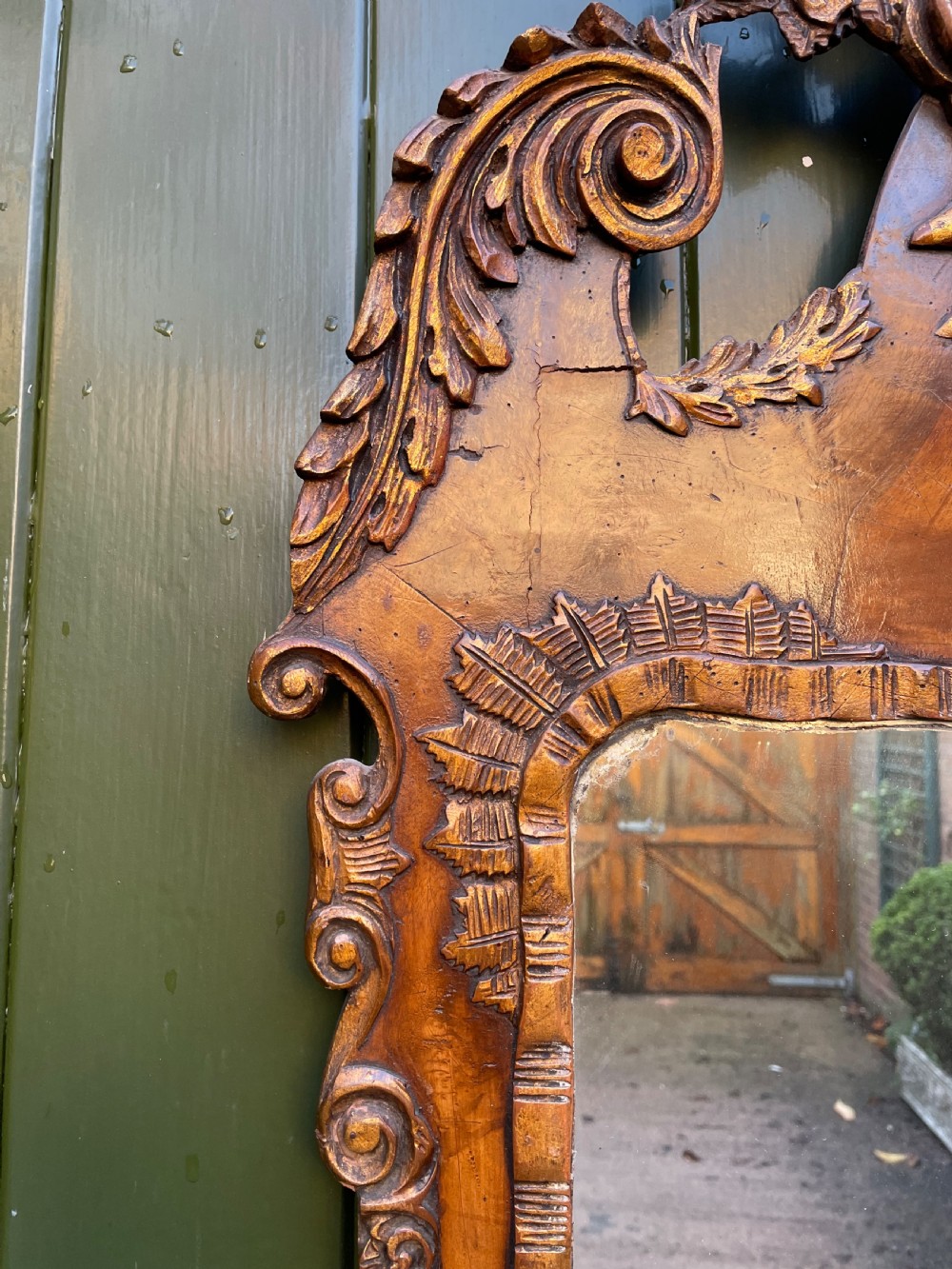 A pair of late nineteenth century carved walnut and parcel-gilt wall consoles with matching arch-top mirrors featuring urn and floral cresting. View XVI
