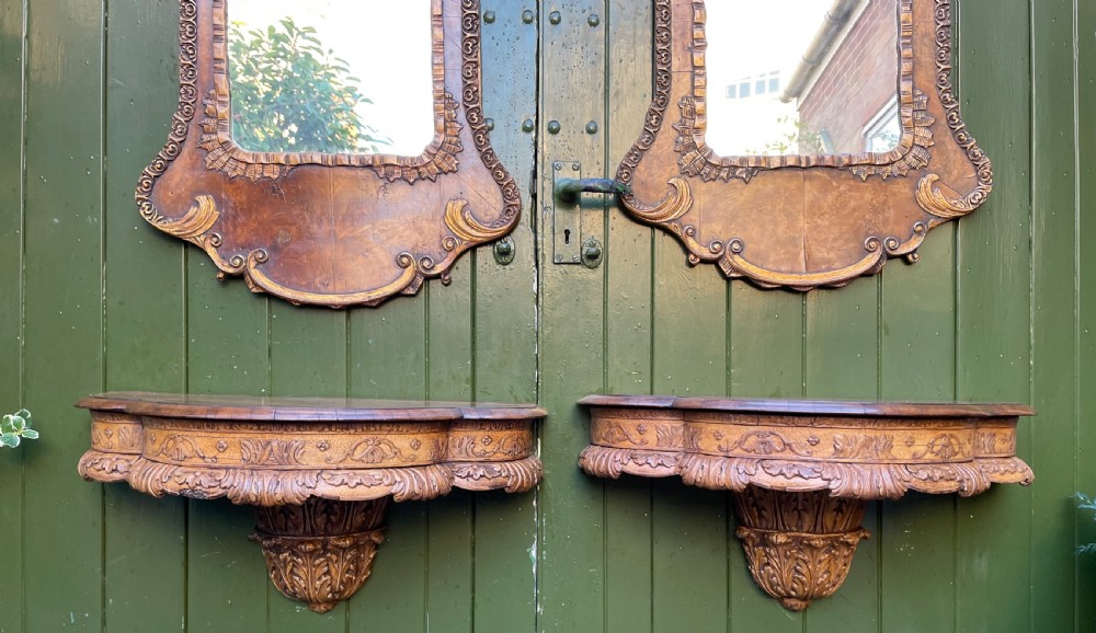 A pair of late nineteenth century carved walnut and parcel-gilt wall consoles with matching arch-top mirrors featuring urn and floral cresting. View XXII