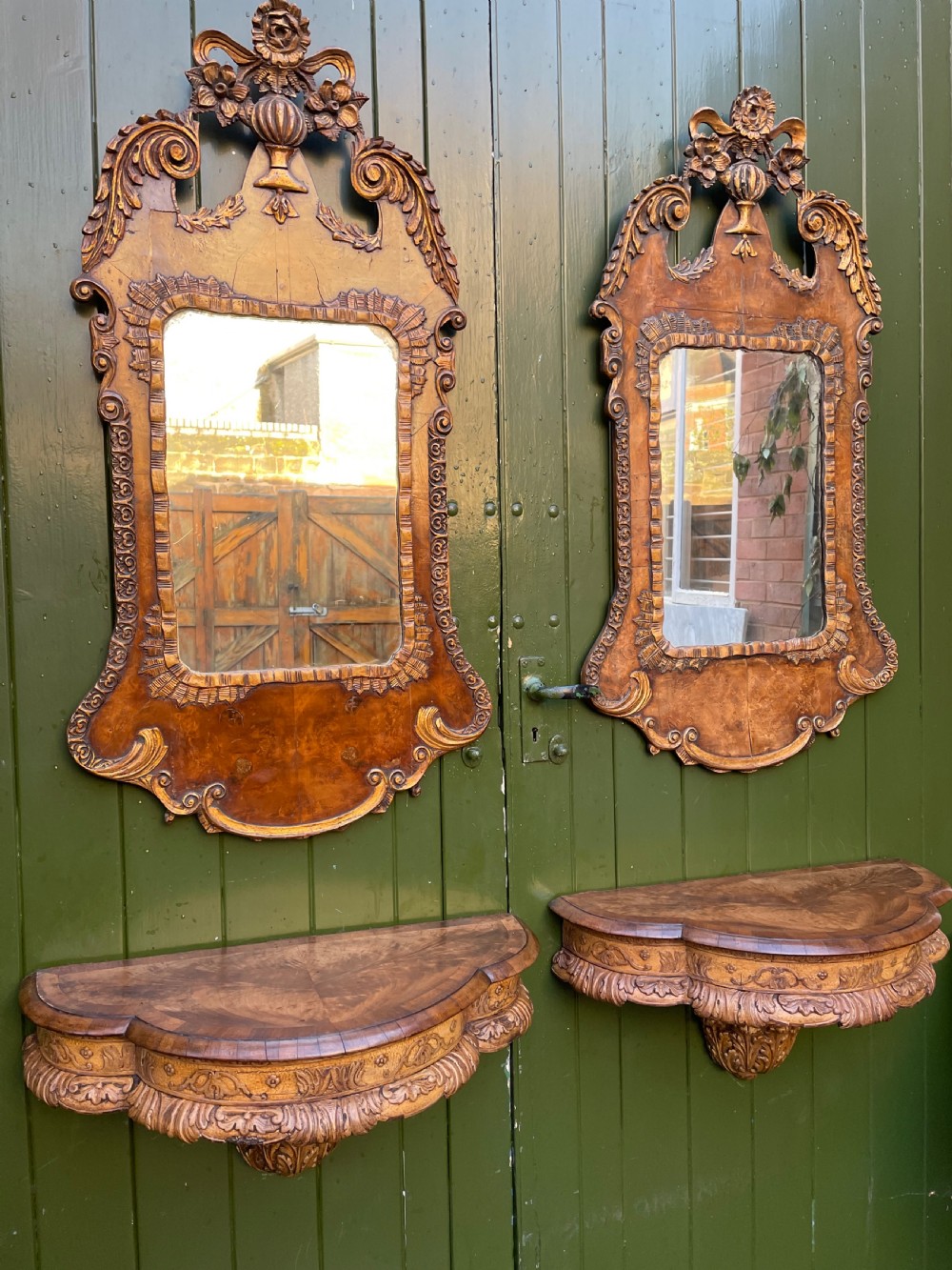 A pair of late nineteenth century carved walnut and parcel-gilt wall consoles with matching arch-top mirrors featuring urn and floral cresting. View XXV